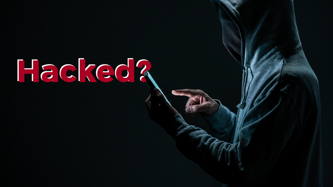 shady character with word "hacked" on screen